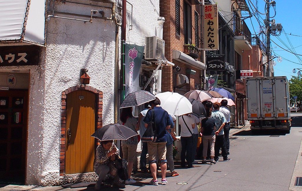 「わんたんや」の前に行列をつくる人々